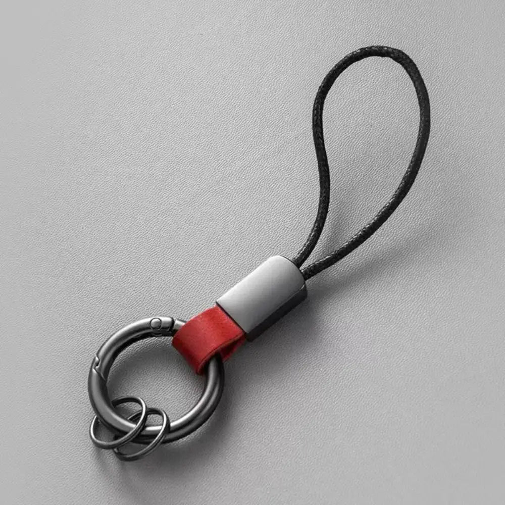 A sleek black cord leather carabinieri keychain with a silver-toned metal carabiner ring and a vibrant red leather strap designed as an anti-lost business key holder.