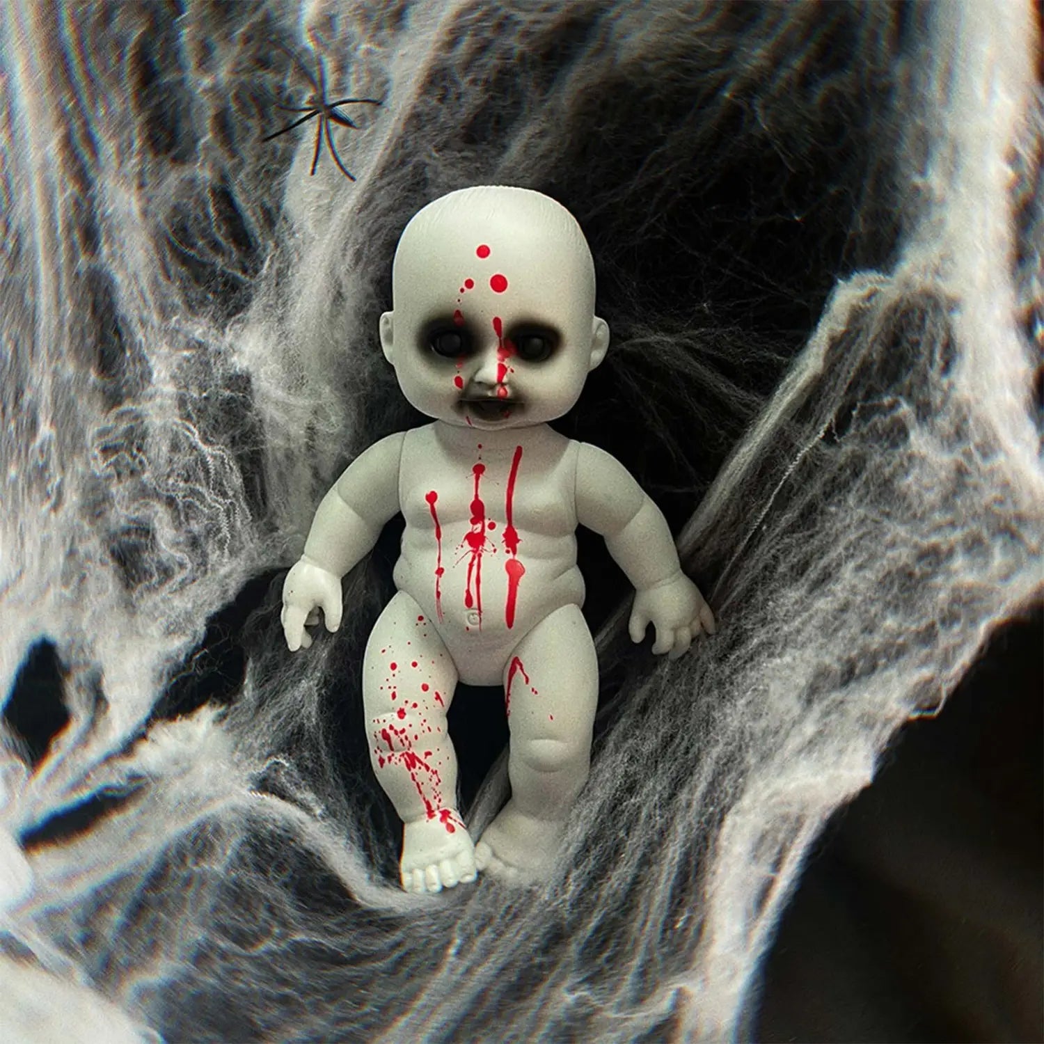 white porcelain baby doll with red paint splatters and black eye sockets designed as a halloween hanging ghost doll spooky prop