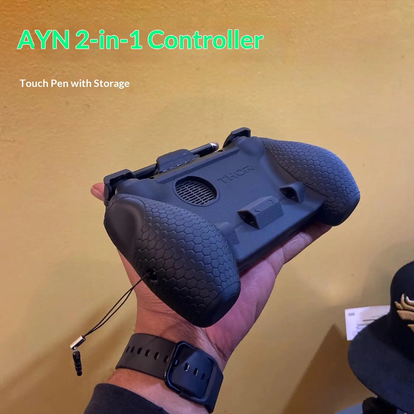 Ayn Thor エルゴノミックグリップ保護ケースおよびアクセサリーの一部として、背面側から示した、テクスチャ加工のグリップと統合されたタッチペン収納を備えたブラックのAyn 2-in-1コントローラー。