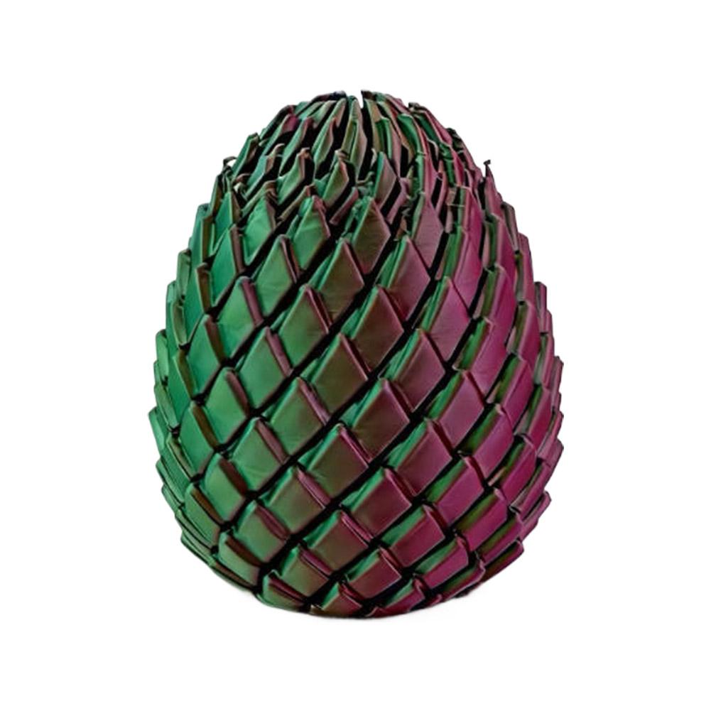 A front view of a glossy, oval-shaped articulated dragon egg fidget toy with a textured surface of interlocking green and purple scales.