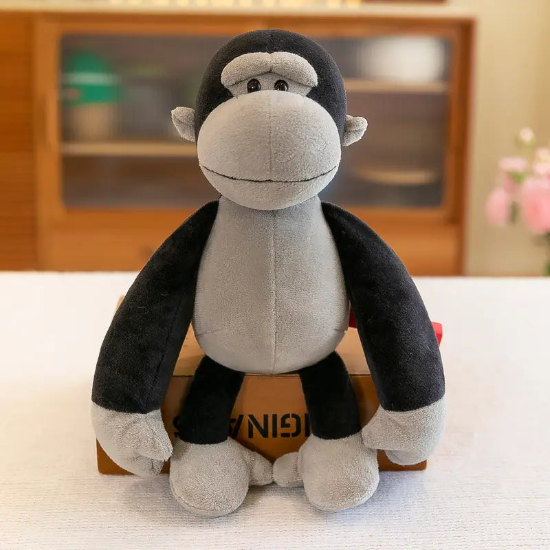 Jouet gorille noir et gris en peluche, fabriqué dans un tissu doux à texture, faisant partie d’une collection d’animaux en peluche rembourrés comprenant des jouets lion éléphant tigre de la forêt.
