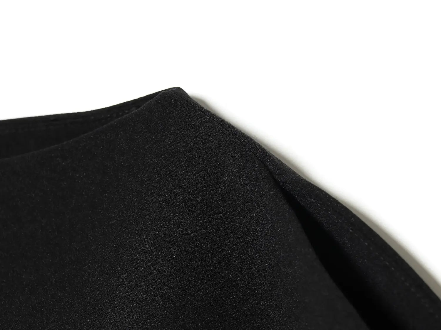 black cotton fabric with a soft textured surface and neatly stitched seam highlighting the sleeve style of a puff sleeve white blouse casual loose summer top