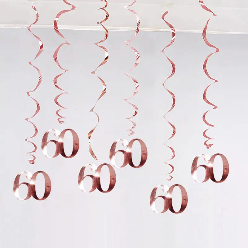 Guirlandes spirales métalliques doré rosé avec des découpes du numéro 60 suspendues pour des décorations en tourbillon d’anniversaire pour des âges variés.
