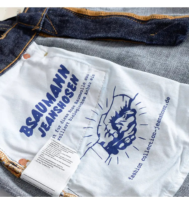 white fabric label with blue text and handshake graphic on the back of heavyweight red selvedge denim jeans from bsaumann jeanshosen featuring brand name and website information