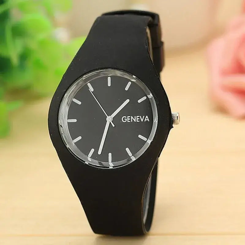 Montre à quartz pour femmes à bracelet en silicone noir, cadran gris foncé minimaliste avec index bâtons blancs et logo Genève sous la position 12 heures (12 o’clock), conçue pour un usage vestimentaire décontracté.