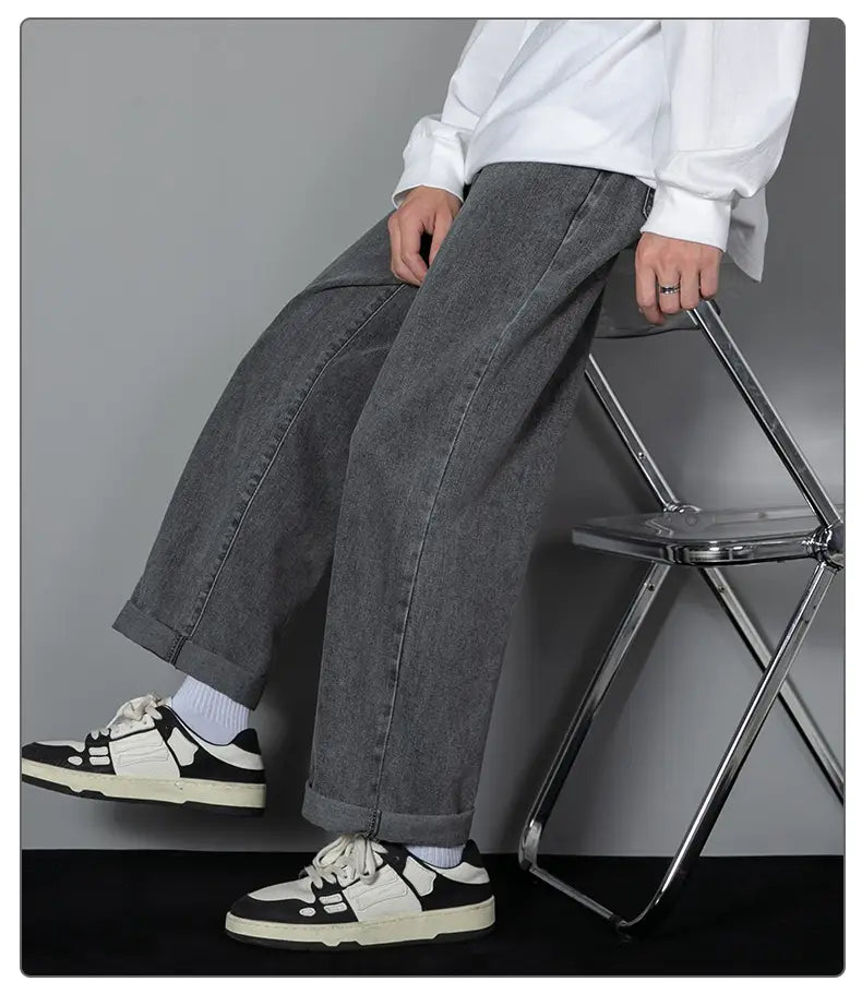 Herren-Casual-Jeans in geradem Schnitt mit weitem Bein in Grau mit entspannter zulaufender Passform und umgeschlagenen Säumen aus Denim-Material.