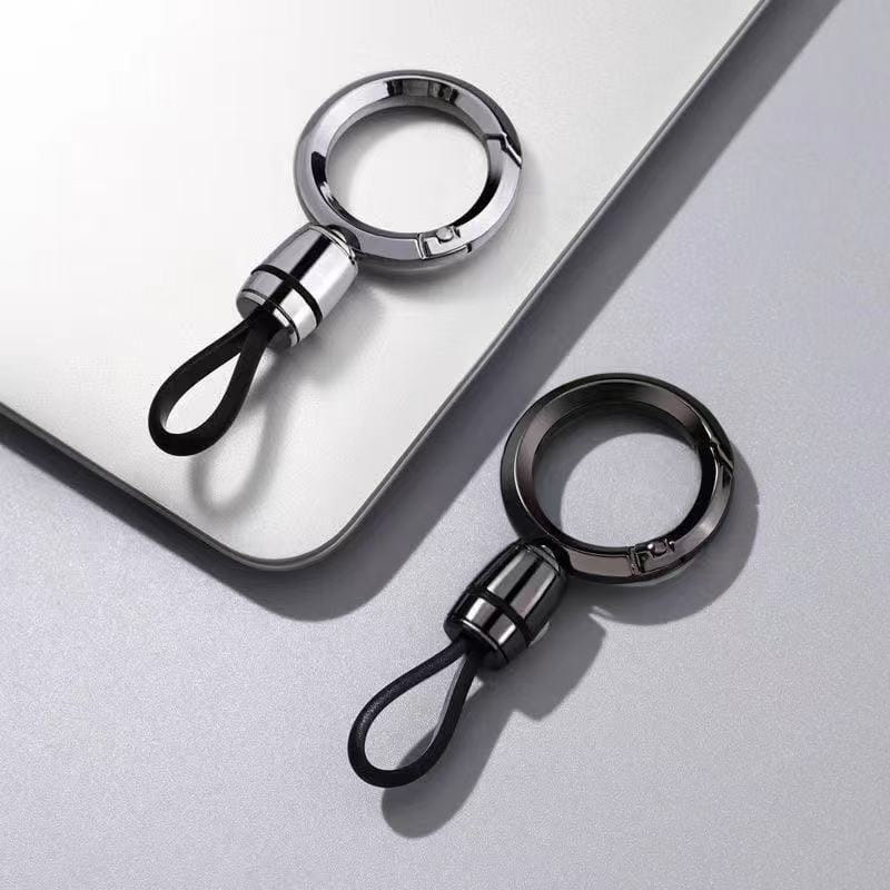 Dos mosquetones magnéticos de metal elegantes con llaveros en plata pulida y negro mate, con conectores cilíndricos ranurados y bucles cortos de goma negra, para uso como anillo de llaves anti-pérdida.