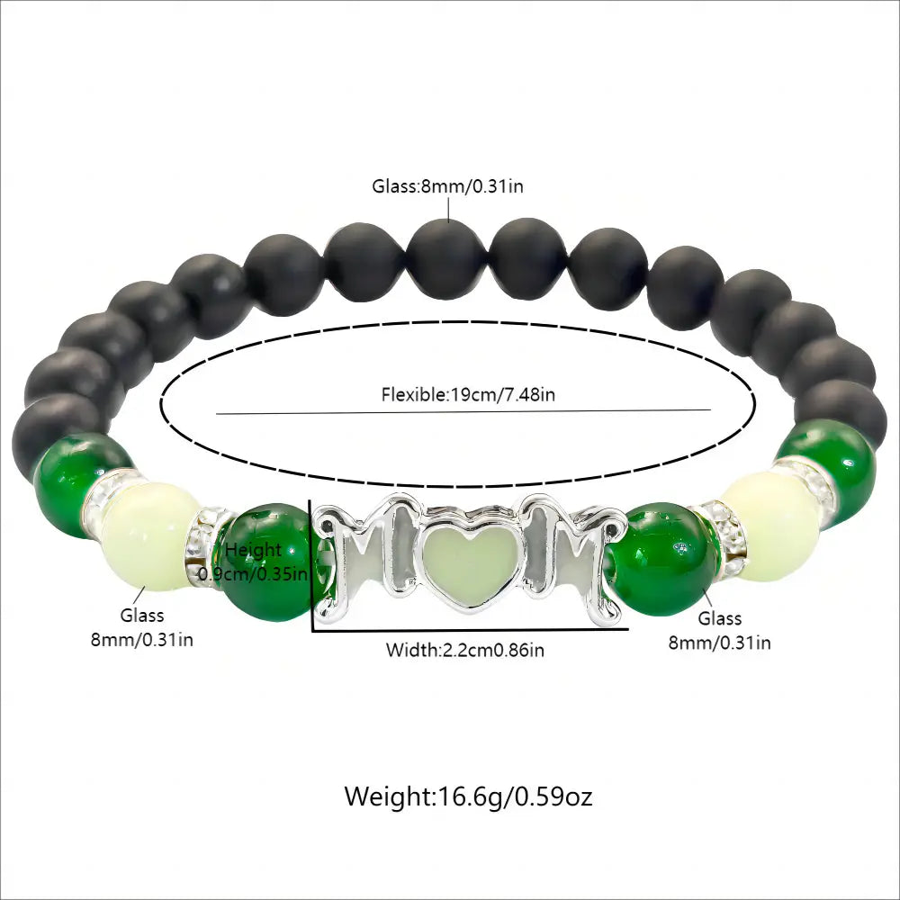 Pulsera esbelta para madre con brillo en la oscuridad de cuentas de vidrio negro y verde, con un dije plateado para mamá con un corazón en el centro.
