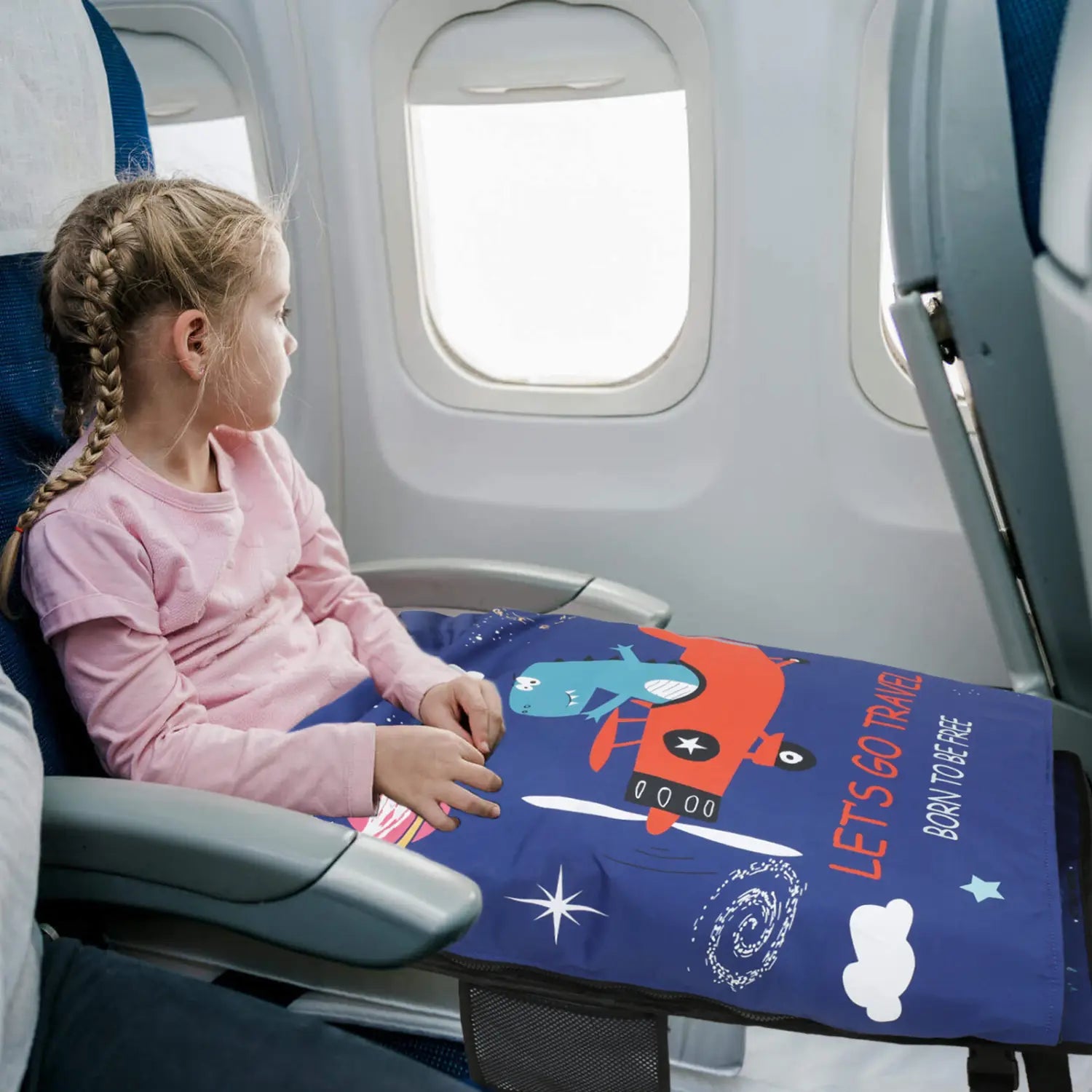 Aufsatz für den Kindersitz im Flugzeug als Reisebett für Kleinkinder mit einer blauen Reisedecke mit Flugzeugthema, mit Cartoon-Flugzeugen und Sternen.