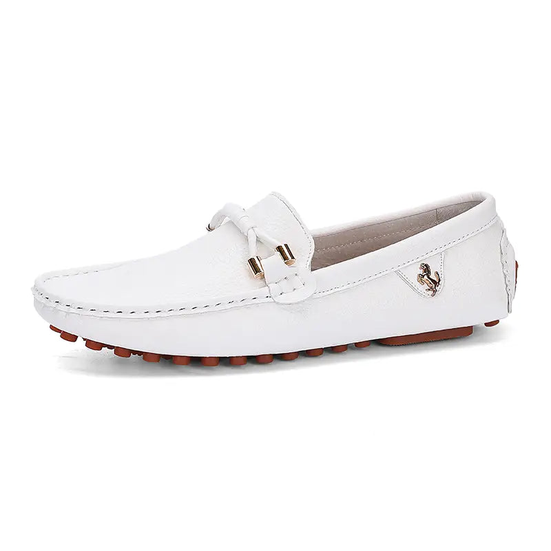 Les chaussures à enfiler habillées en cuir se portent sans effort avec des chaussures décontractées en cuir blanc, avec un emblème équestre ton or et des semelles en caoutchouc marron.