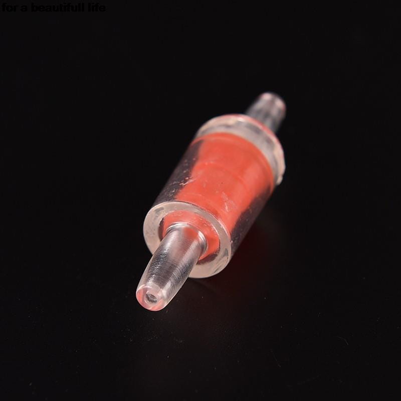 Válvula de retención de plástico transparente para bomba de aire de acuario con un elemento filtrante interno rojo para el control del flujo de aire unidireccional.