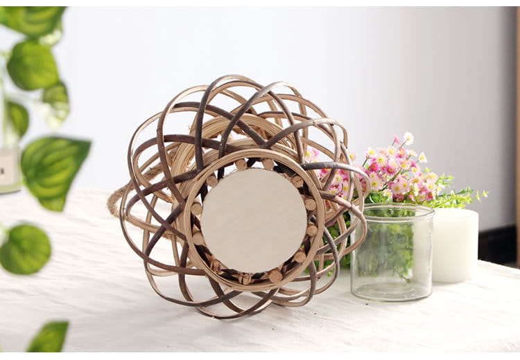 Un miroir décoratif en rotin tissé, avec un cadre circulaire aux tons brun naturel, adapté à la décoration intérieure du domicile et complétant un porte-bougie en bambou tissé.