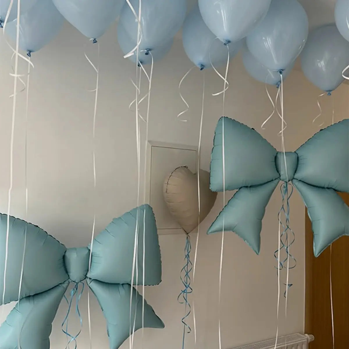 light blue glossy foil balloon bows with white ribbons from the blue bear and bow balloon party set