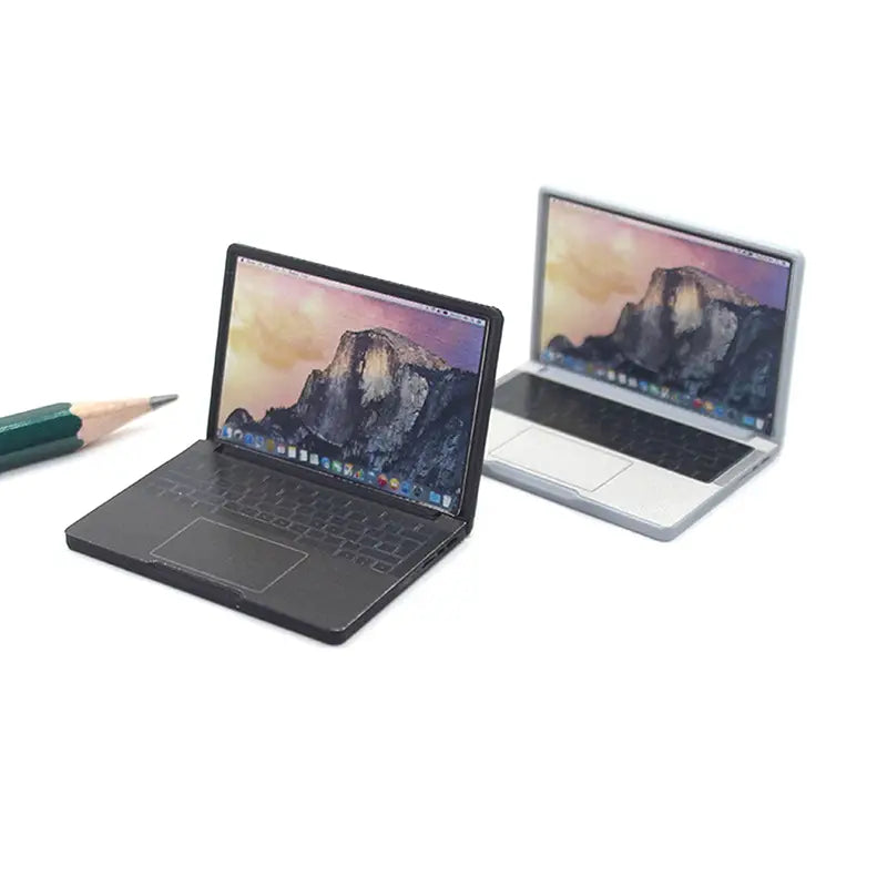 Black mini laptop with a sleek matte alloy finish and an illuminated screen displaying yosemite mountain wallpaper for a doll house accessory.