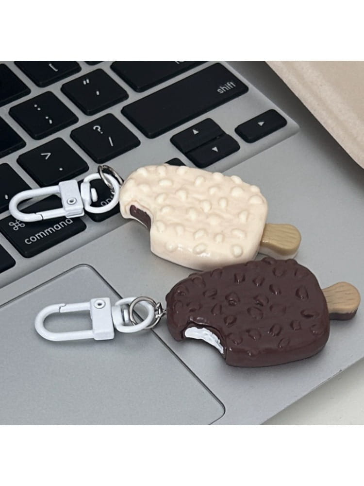 two ice cream-themed chocolate biscuit cartoon key chain bag pendants with creamy white and dark chocolate textured coatings mimicking real ice cream surfaces.