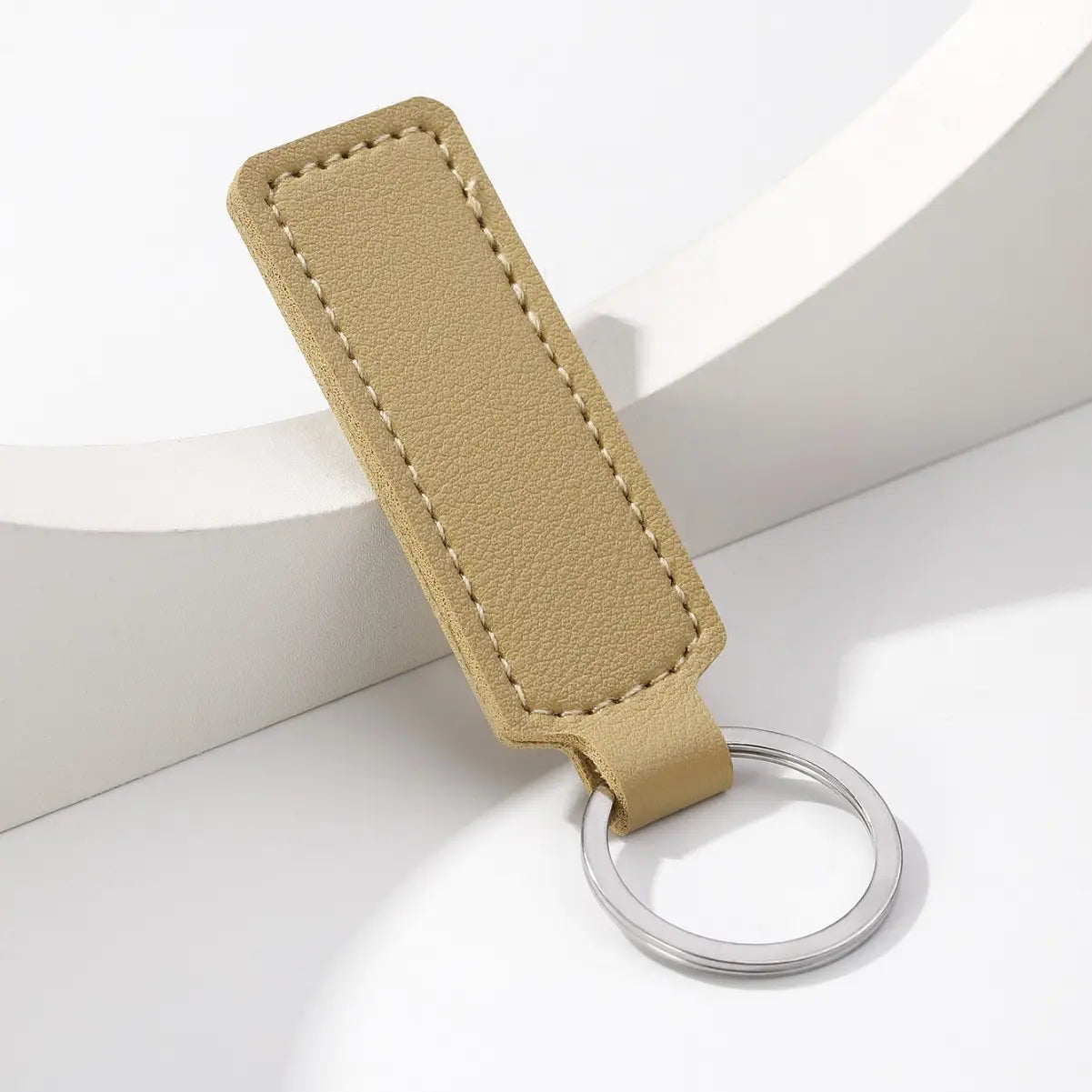 Tan leather minimalist strip key ring featuring a silver metal ring for car keys.