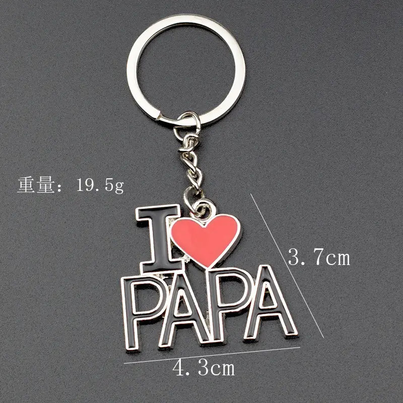 Geschenkset für einen Metall-Schlüsselanhänger im Familienbuchstaben-Look aus silbernem Metall mit einem „I heart papa“-Design, schwarzer Emaille-Schrift und einem roten Herz, das an einem Kreisring durch eine kurze Kette befestigt ist.