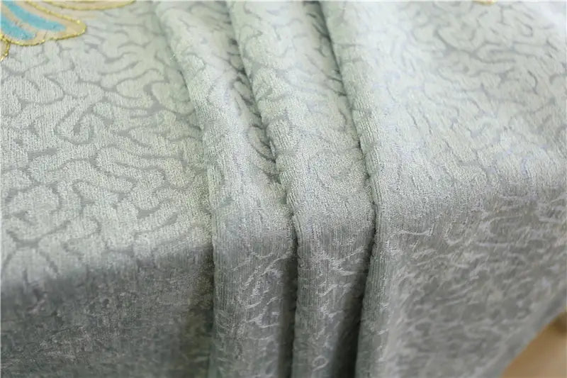 a soft light gray fabric with a subtle woven pattern and delicate gold and blue embroidery used in embroidered living room curtains for french window