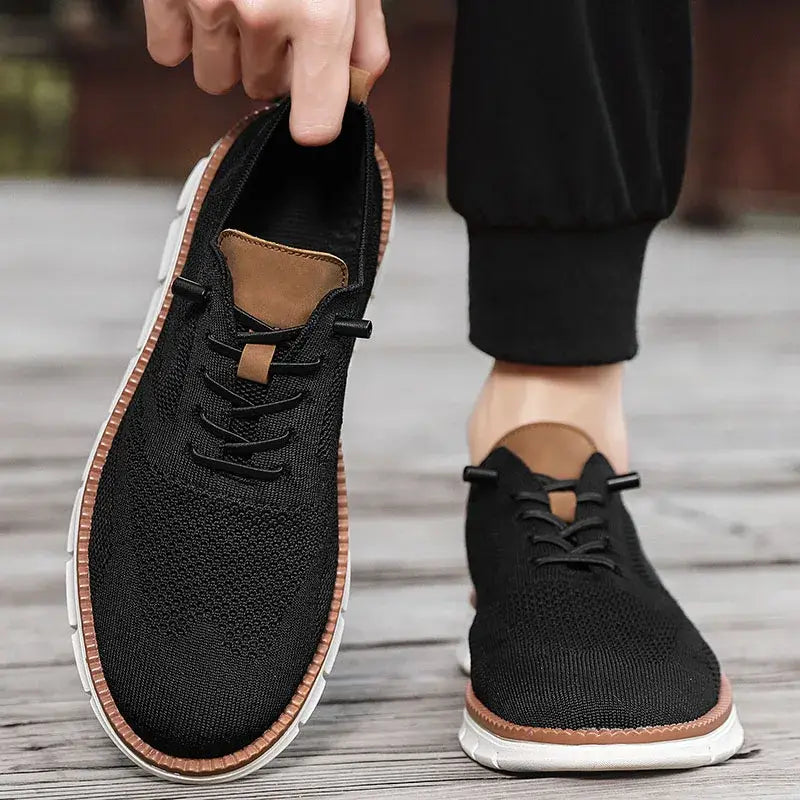 Chaussures derby brogue décontractées en maille pour hommes, de couleur noire, avec des accents en cuir tan et une semelle en caoutchouc blanc.