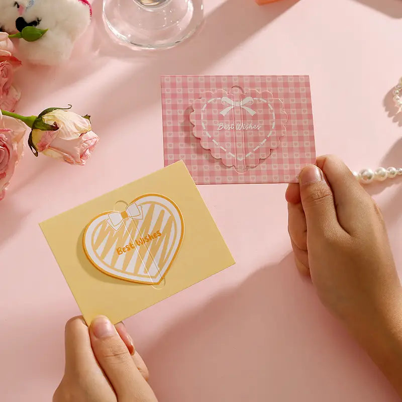 Two heart-shaped 3d heart greeting cards featuring a pink and white checkered pattern with a clear bow design and a yellow cardstock card with gold zebra-striped hearts for pastel valentine and wedding notes.