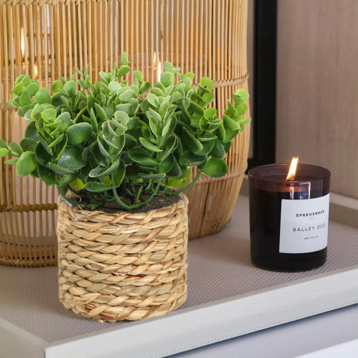 a woven wicker planter containing a lush green artificial eucalyptus plant designed as a small potted plant measuring 17cm