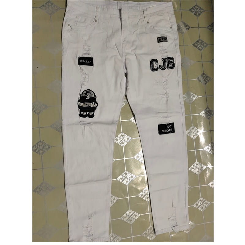 Jeans skinny déchirés slim hip-hop pour hommes, brodés, en denim blanc, avec des patchs brodés noirs portant l’inscription « cjb », un design de personnage de dessin animé et du texte indiquant « chicken » et « eat chicken ».