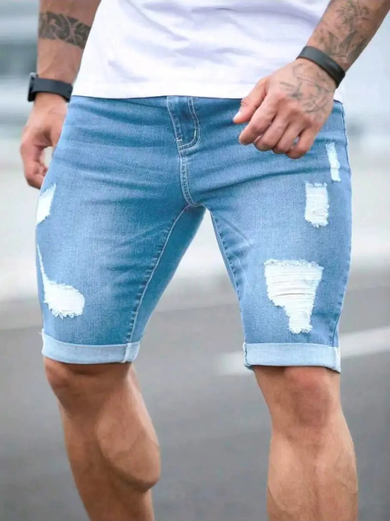 Short en jean noir déchiré pour hommes présentant un tissu délavé avec des écussons déchirés et des revers retroussés.