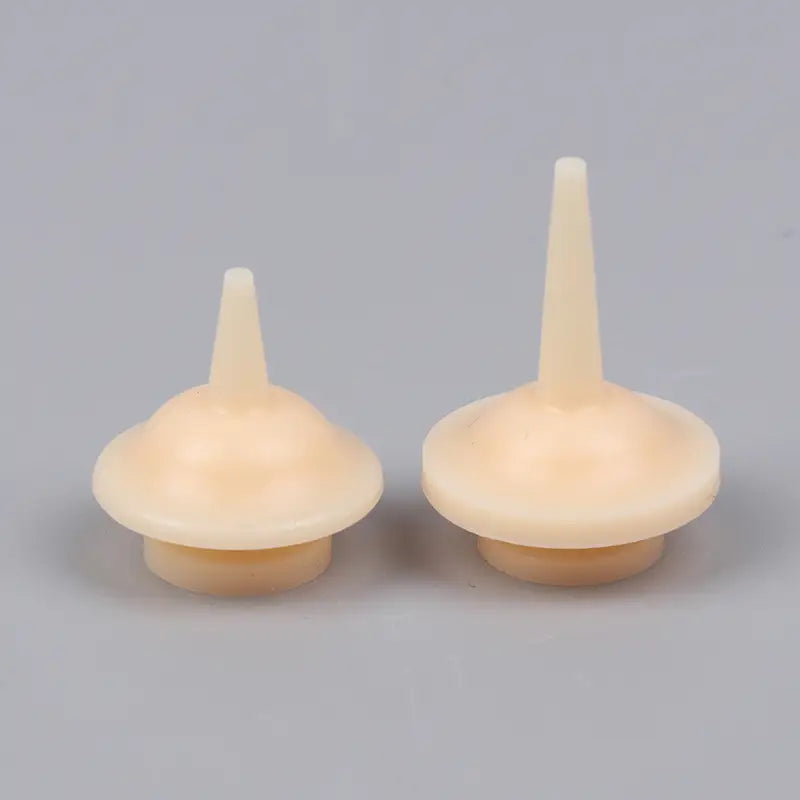 Two beige silicone nipple shields of slightly different sizes for the pet oral syringe feeding set with silicone nipples.
