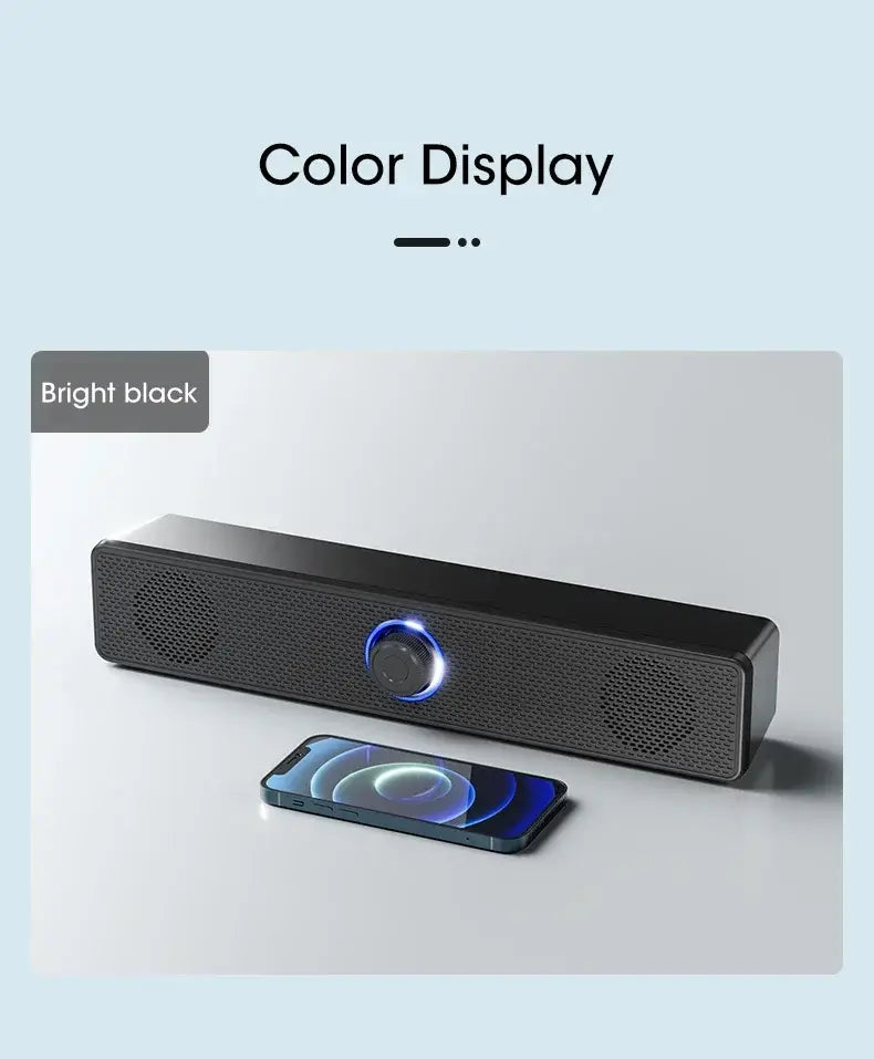 Bright black Bluetooth computer speaker wireless desktop soundbar with a central glowing blue circular display and perforated speaker grilles.