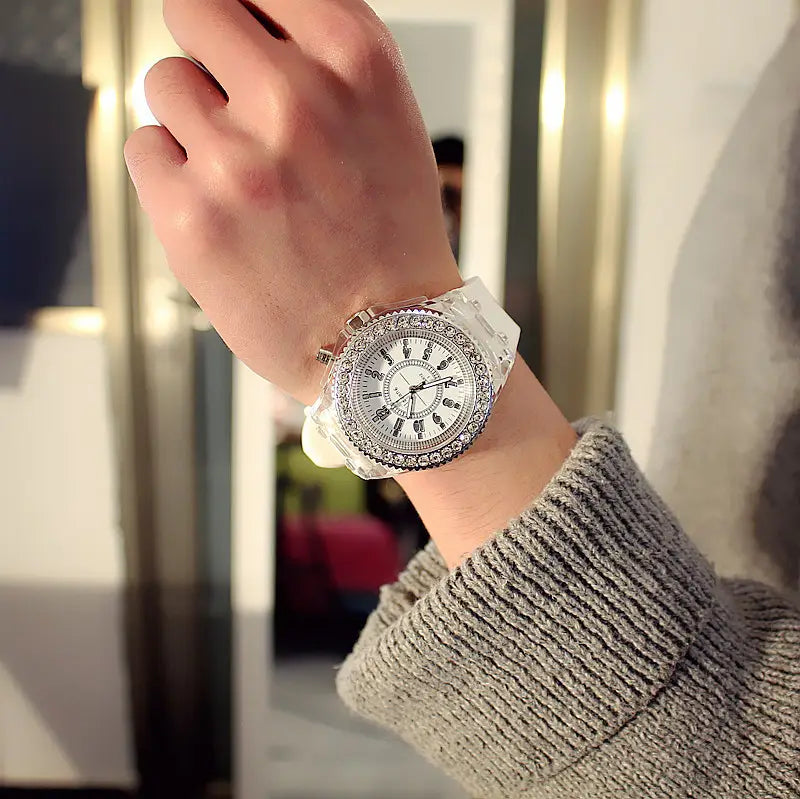 a sparkling white crystal-encrusted led luminous silicone watch with a transparent band worn on a wrist