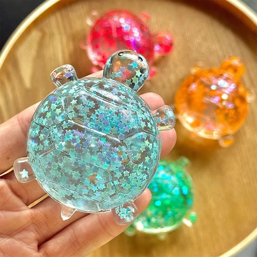 Ein durchscheinender Teal/Smaragd-Schimmer-Schildkröten-Spielzeug-Fidget-Spielzeug-Stressball, gefüllt mit funkelndem Sternenglitzer, entworfen für weiches Knautschen zur Stresslinderung.