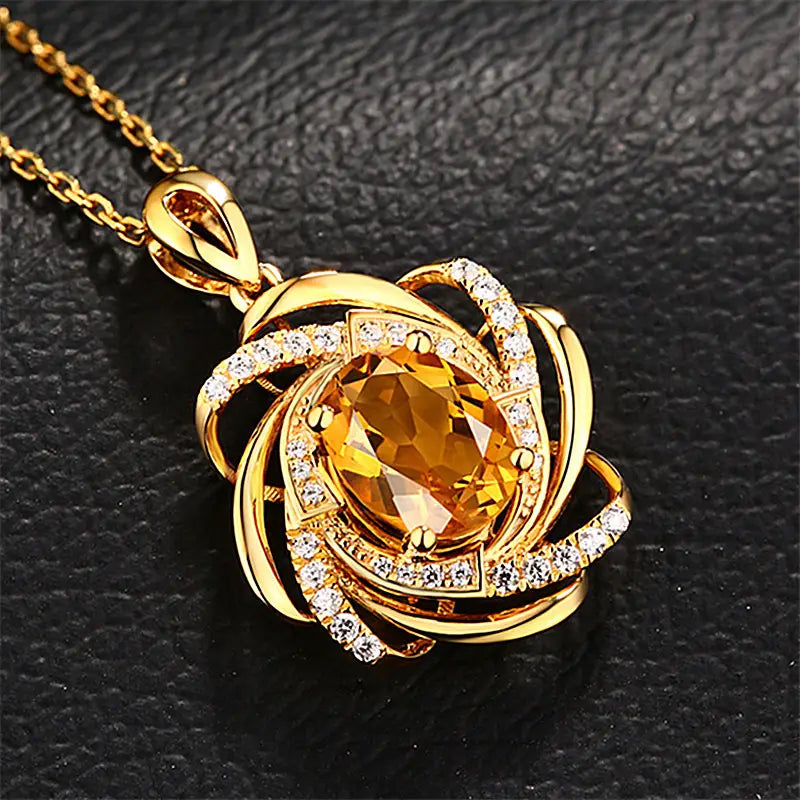 collier pendentif en or, moulin à vent en citrine, comportant une pierre ovale centrale en citrine entourée de bandes dorées tourbillonnantes et de petits diamants transparents fixés à une chaîne dorée assortie