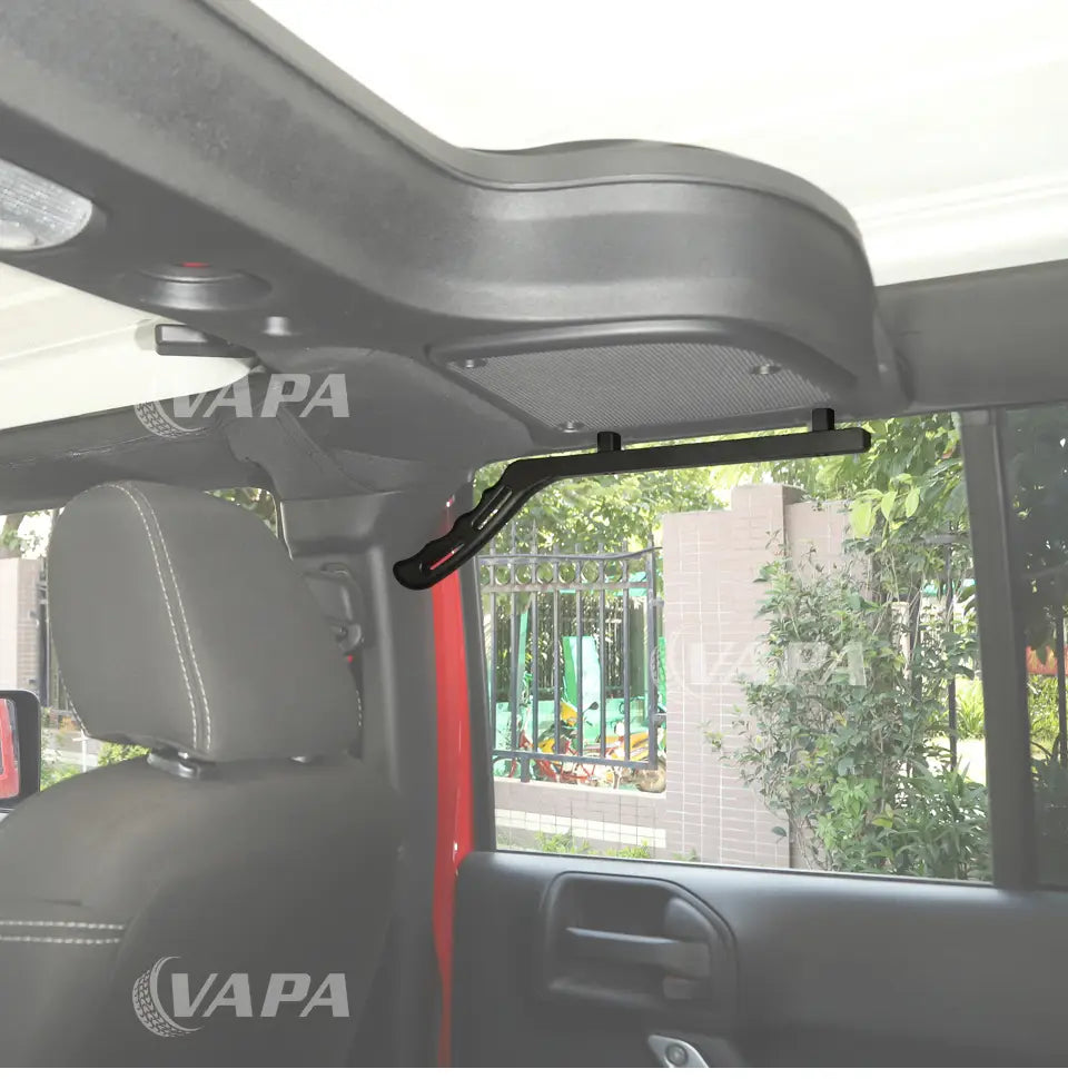 Schwarzer Metall-Dachträger im Inneren eines Fahrzeugs montiert, dargestellt neben Jeep Wrangler JK Aluminium-Türgriff-Garnituren in Schwarz und Rot, für erhöhte Robustheit und Stil