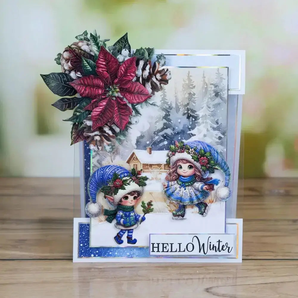 a festive winter-themed christmas metal cutting die and stamp set featuring two illustrated children in blue and white holiday attire with a large red poinsettia flower and pinecones