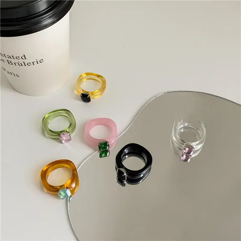 Colorful resin crystal geometric ring for women featuring translucent bands with square-cut gemstones in yellow green pink orange and black hues.