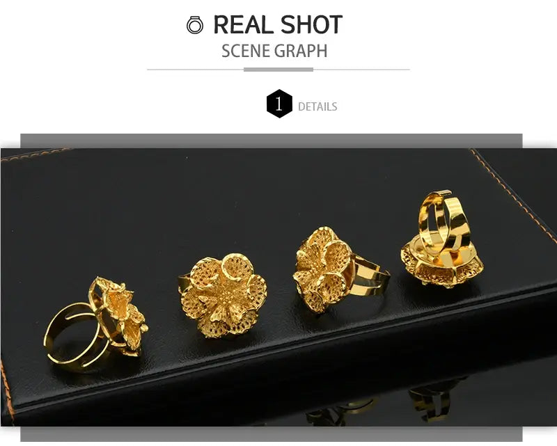 Four gold plated 24k gold floral rings with intricate openwork designs on a black surface featured as dubai jewelry spiral rings for women.