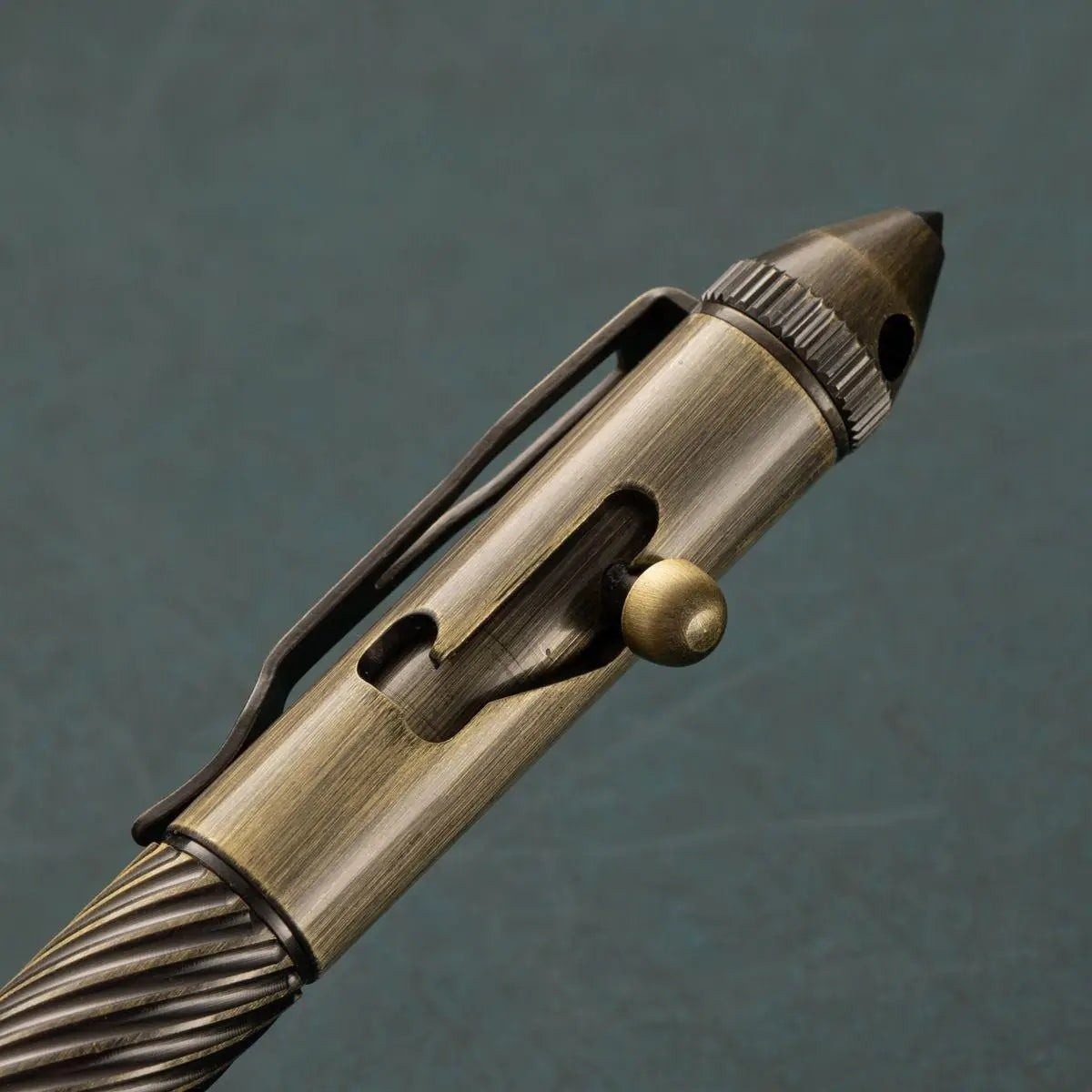 Un stylo tactique ancien fini en laiton, pour hommes, avec prise texturée et clip de porte-clés intégré, présenté comme stylo de voyage rétro en laiton pour hommes.