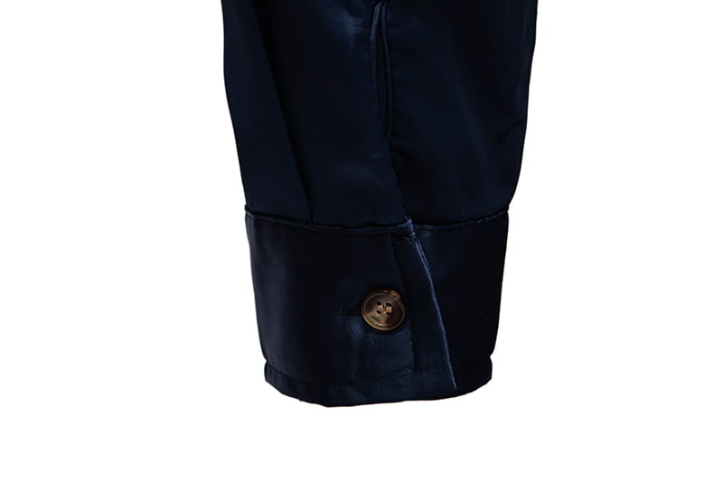 Dunkelnavyblauer Satinstoff-Manschettenabschluss mit einem goldfarbenen Knopf am Herrenhemd mit goldfarbenem Besatz aus Satin.