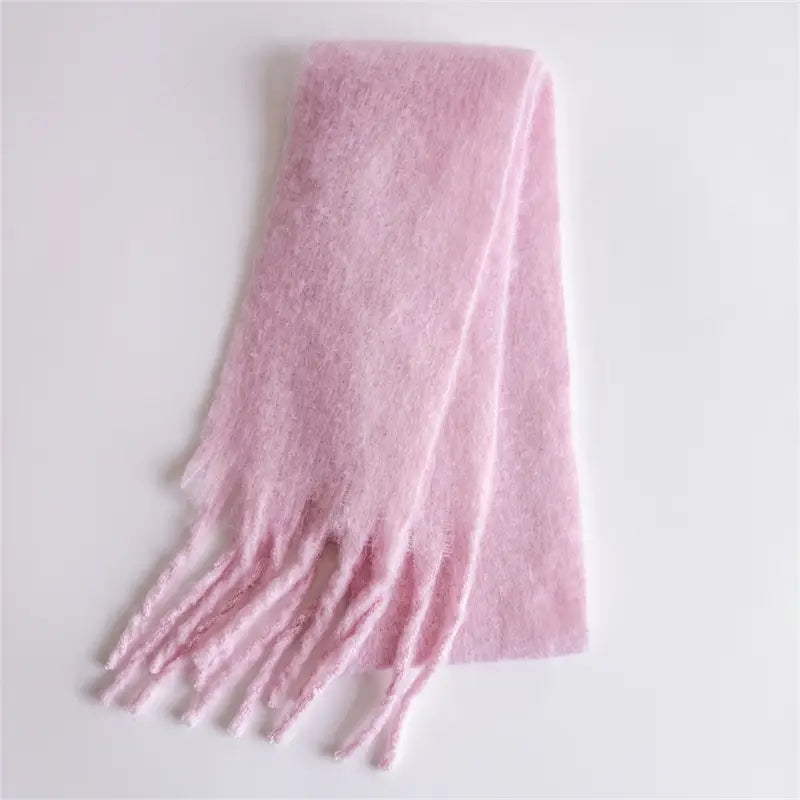 Ein weicher Pastellrosa-Schal für Damen mit Cashmere-ähnlichem Gefühl für den Winter mit flauschiger Textur und gefransten Enden.
