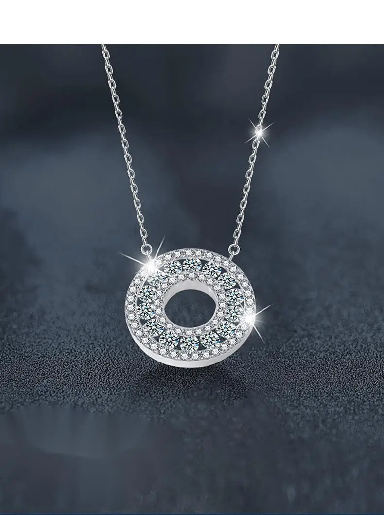 Collar con colgante de halo de moissanita de plata con un colgante circular plateado brillante, adornado con numerosas piedras facetadas transparentes, engastadas en un patrón intrincado.