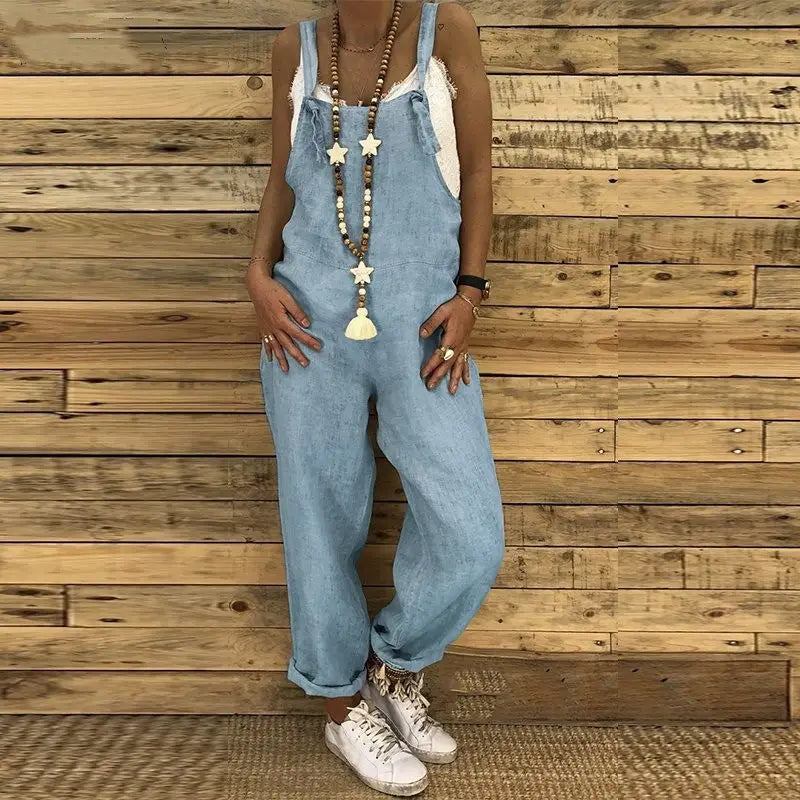 Hellblaue Jeans-Latzhosen für Damen in lockerer Sommerausführung mit entspannter Passform und hochgekrempelten Bündchen.