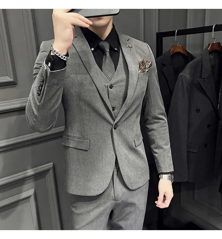 Ensemble de costume trois pièces slim fit pour homme en tissu gris texturé, avec un motif subtil type chevrons, comprenant un gilet assorti et 9 pantalons courts à la cheville, avec un type de fermeture par boutons.
