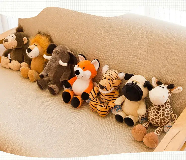 a row of plush stuffed animal toys featuring lion elephant tiger designs along with monkey, fox, zebra, and giraffe arranged neatly on a beige couch