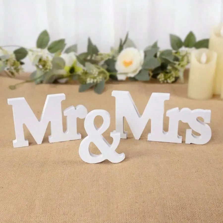 Weißes hölzernes Hochzeitstischschild mit den Buchstaben „Mr“ und „Mrs“ als Dekoration für ein Hochzeitsevent-Zentrumstück