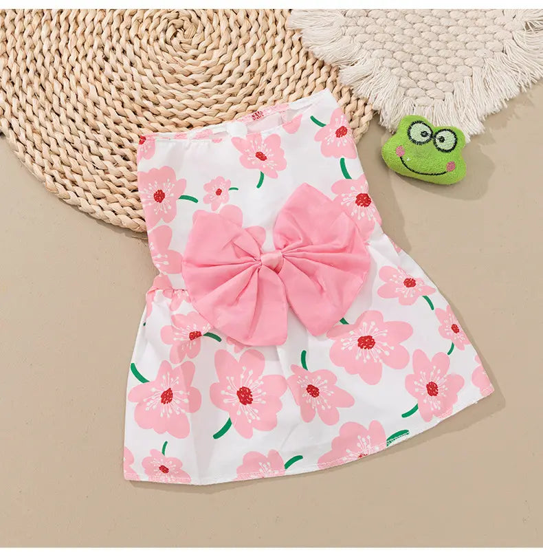 A floral dog princess dress with pink floral patterns featuring a large soft pink bow at the center.