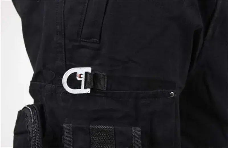 Schwarzer Utility-Gürtel mit Metallschnalle in Silberoptik mit dem Champion-Logo in Kombination mit Herren-Tactical-Cargo-Hosen aus Baumwolle mit Camo-Jogger-Optik