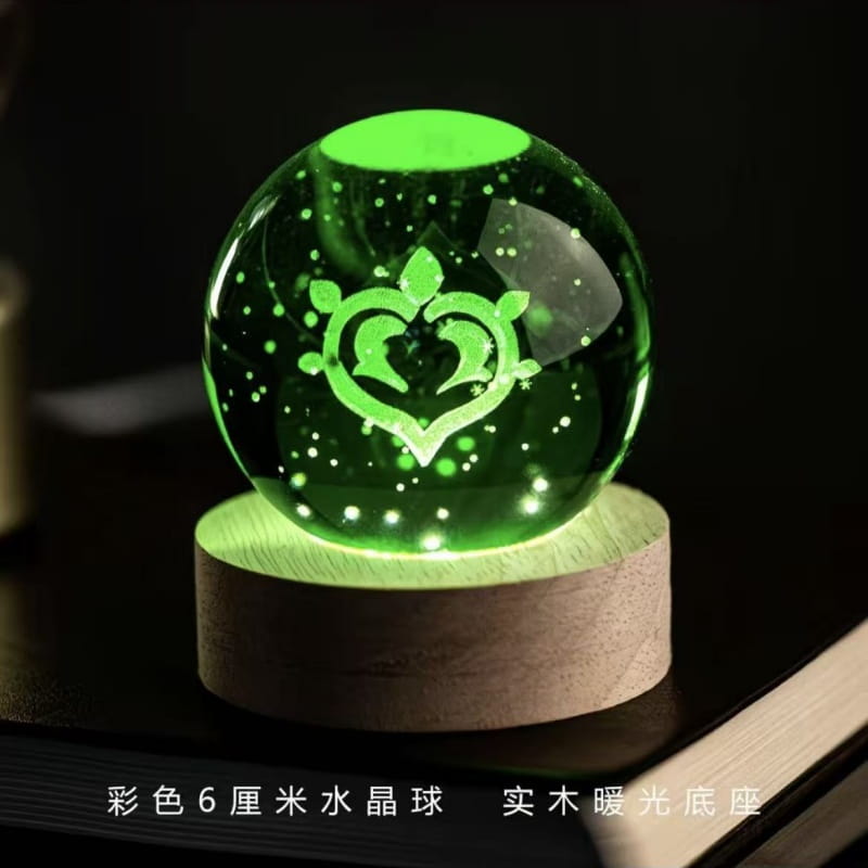 Une boule de cristal verte lumineuse de 6 centimètres, avec un emblème en forme de cœur et un motif constellé, reposant sur une base en bois, comme produit fini de boule de cristal de Genshin Impact.
