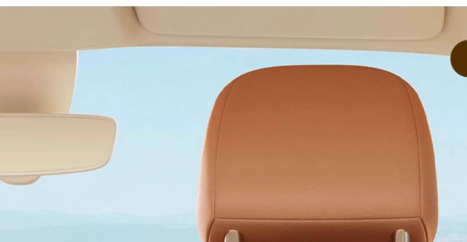 tan leather car headrest with smooth padded surface and subtle edge stitching shown on the back side of a car seat organizer animal alphabet storage pocket.