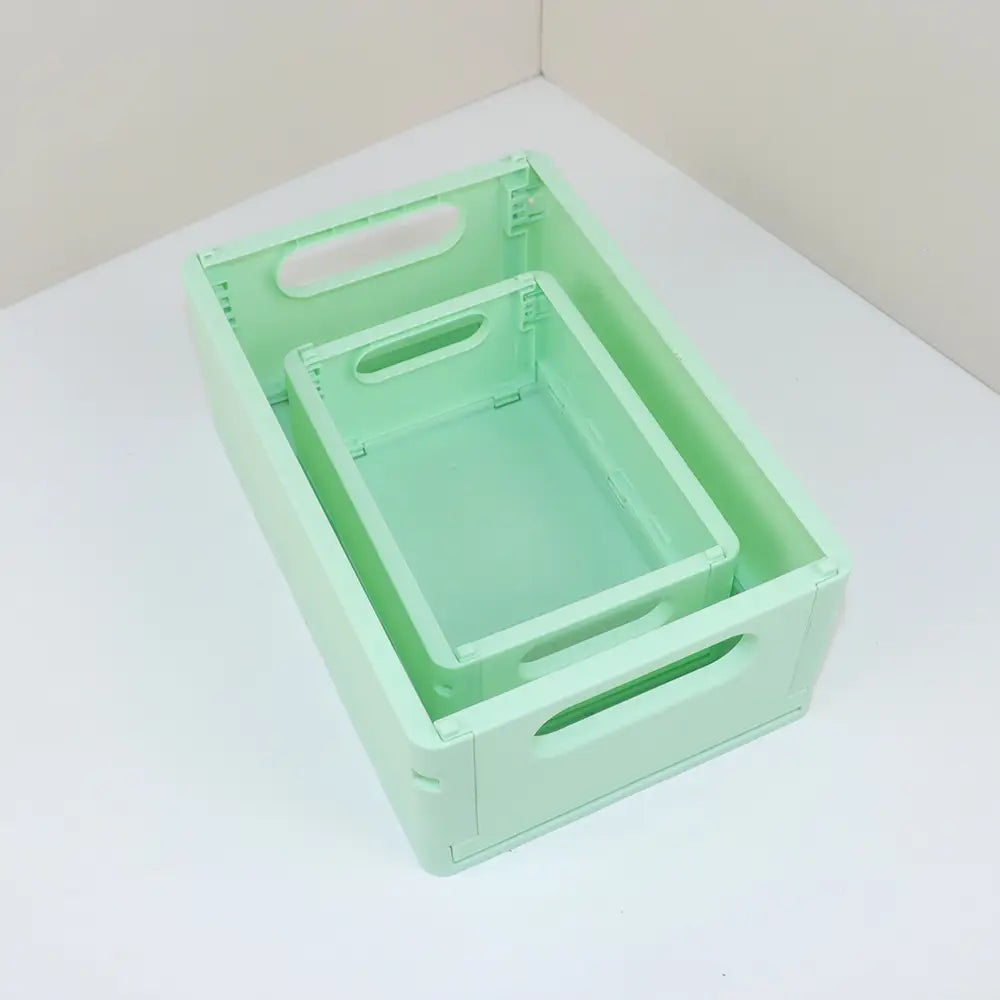 Set aus zwei mintgrünen pastellfarbenen faltbaren Kunststoff-Aufbewahrungsboxen mit integrierten Griffen für die Organisation am Desktop.