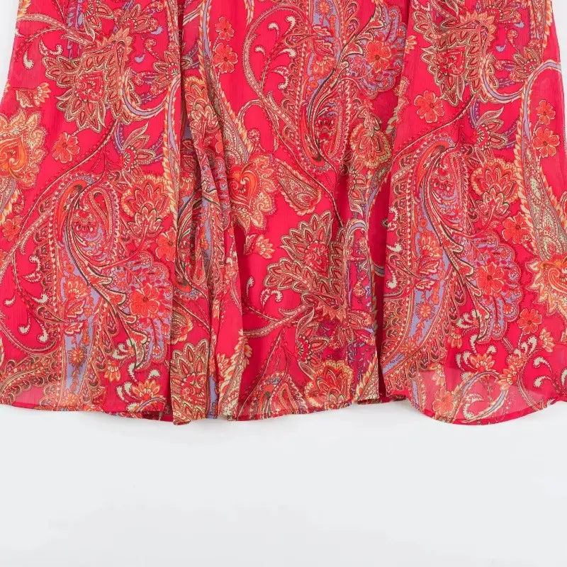 a flowing red midi skirt with an intricate paisley pattern in shades of orange gold and muted blue from the red paisley halter top and midi skirt set